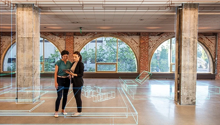 Two workers stand in an empty office with a graphic overlay of coming systems