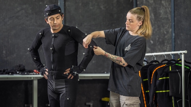 Woman placing motion capture sensors on actor
