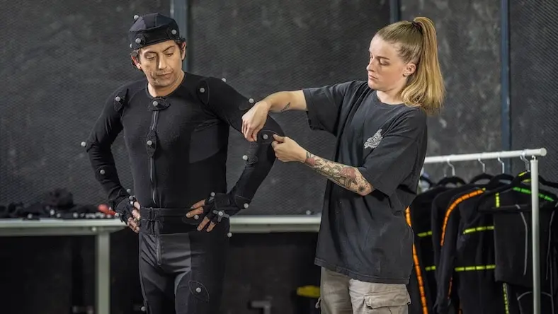 Woman placing motion capture sensors on actor