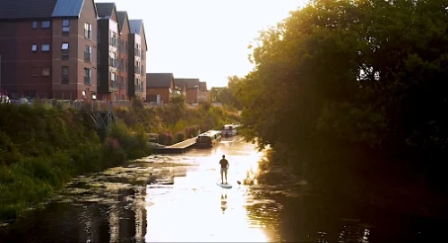 Image of a person paddle boarding down the Scottish Canal