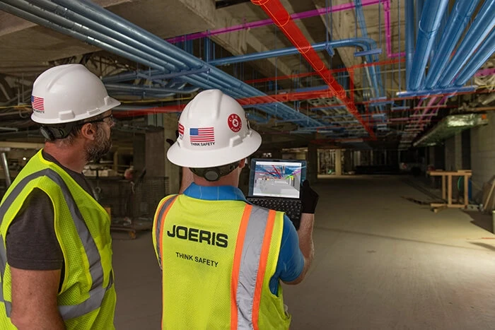 Two construction workers viewing digital model on jobsite