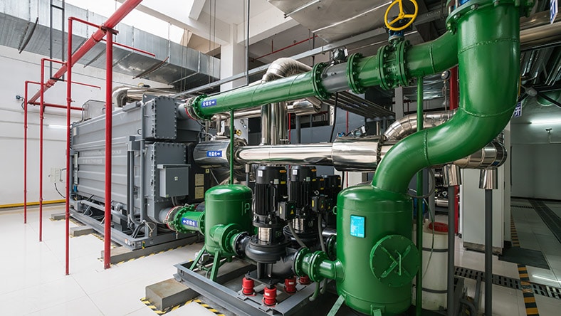 Large heat pumps fill a machine room.