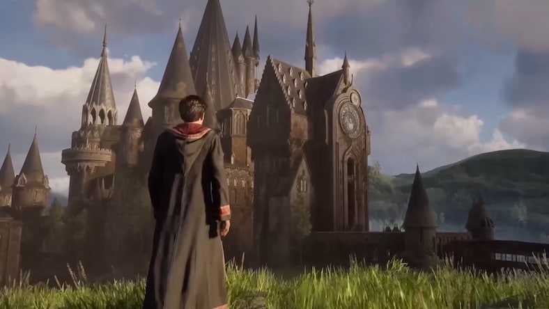 Still from Hogwarts Legacy game showing young wizard in front of castle