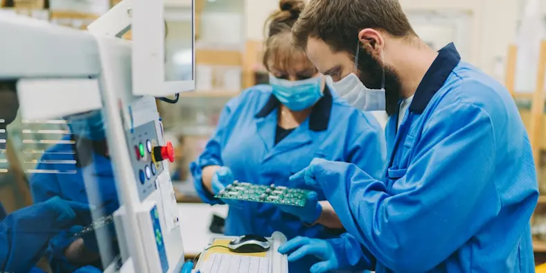 Skills gap in manufacturing quality control at production factory 2 workers with circuit board