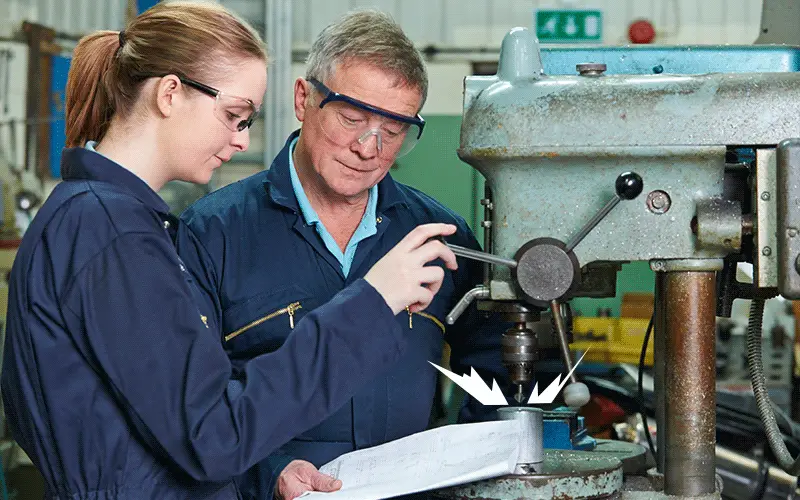 Women in manufacturing mentorship younger woman and older man working in a machine shop animation