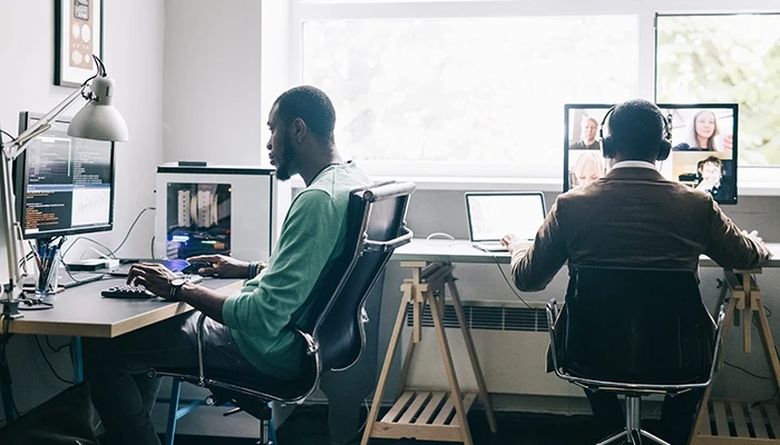 people in an office looking at data on computer screens