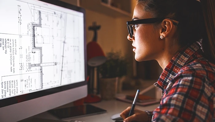 An architect works on a building design on her computer