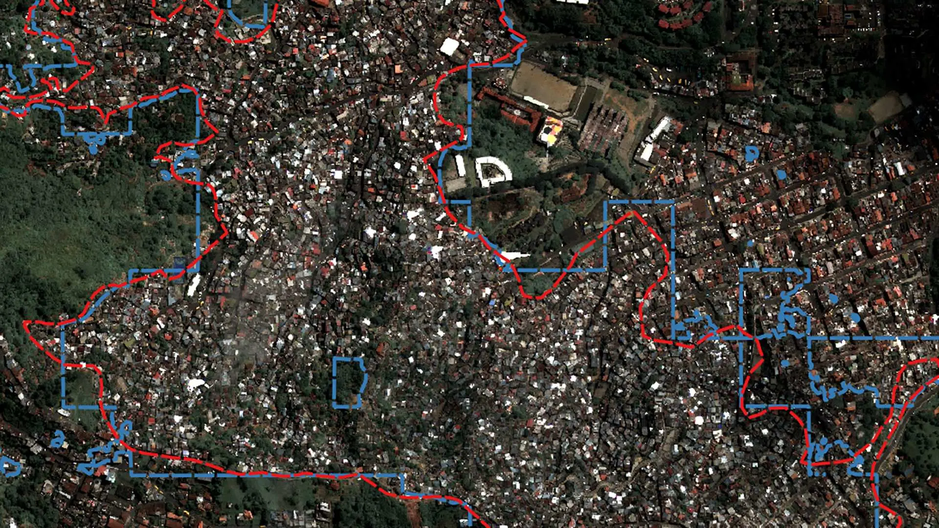 Une image satellite montre un quartier informel avec des points de données superposés en rouge et en bleu.
