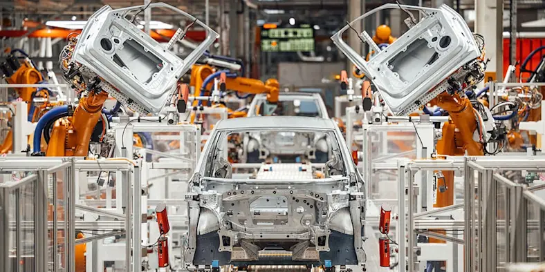 robotic arms working in a car manufacturing facility