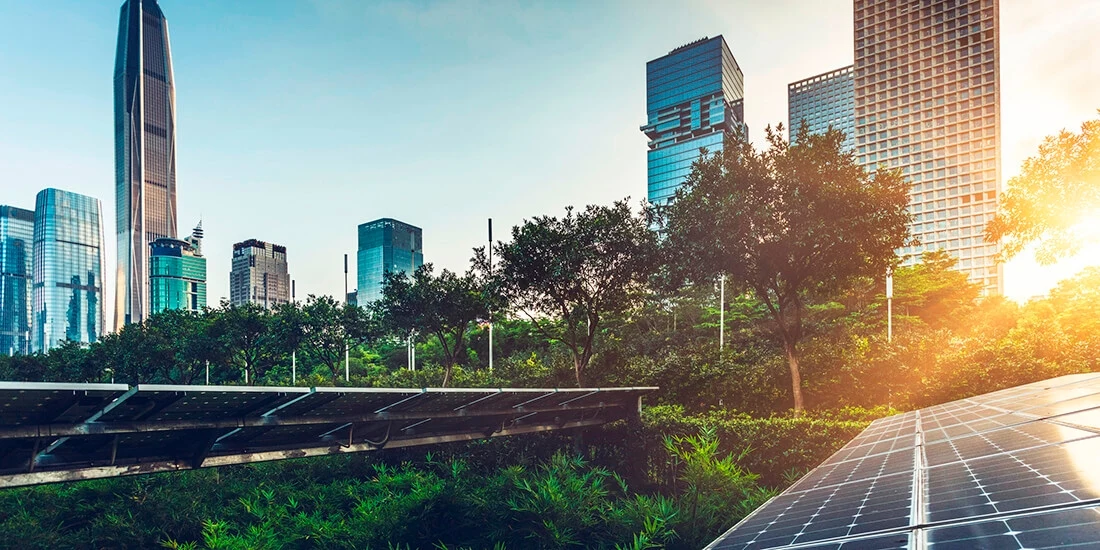 sun rising over a city skyline