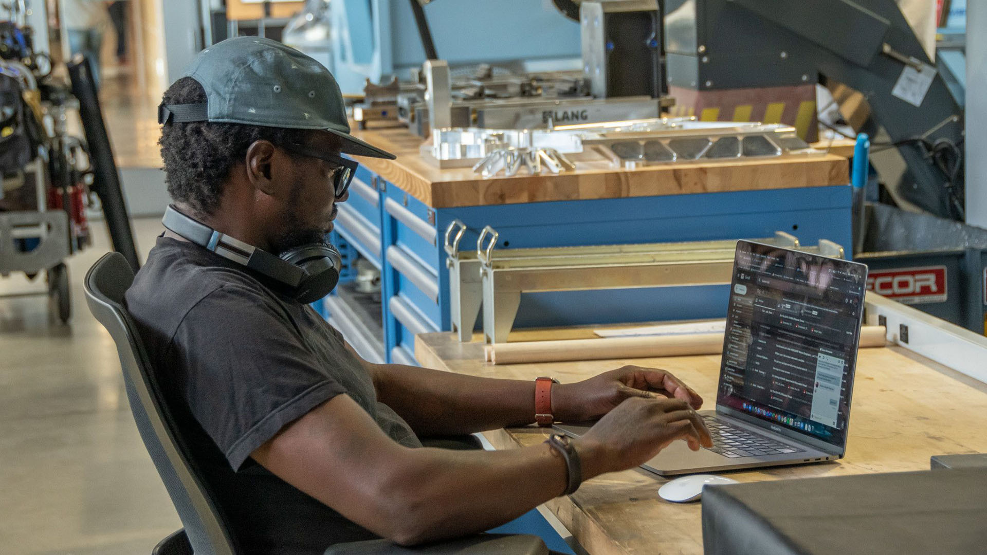 A man sits at a computer in a technology lab.