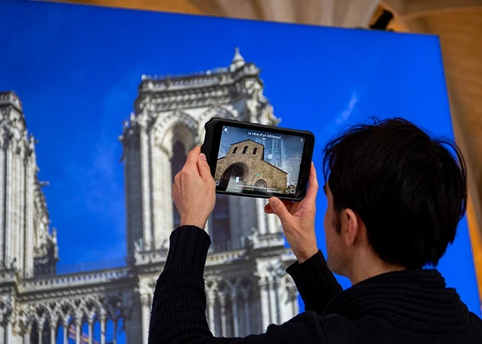 Visitor uses a tablet for virtual tour of Notre-Dame.