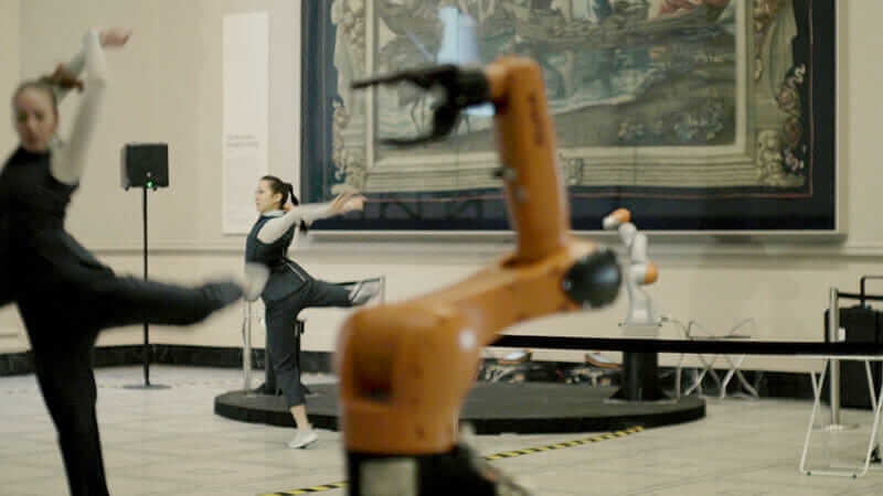 Rose Alice Larkings and Merritt Moore dancing with robots