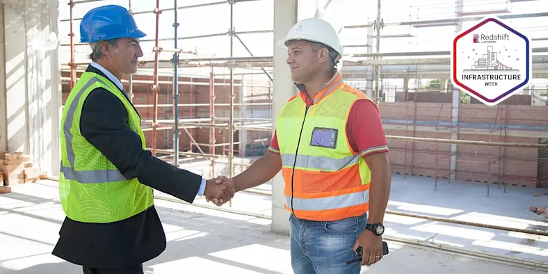 Two people in reflective vests and hard hats.