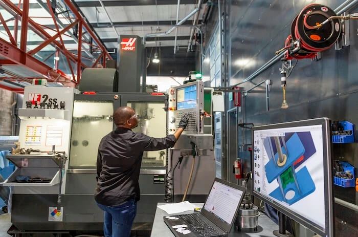 A man operates a CNC machine 