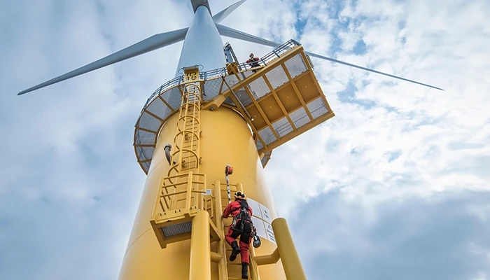 engineers climb a wind turbine