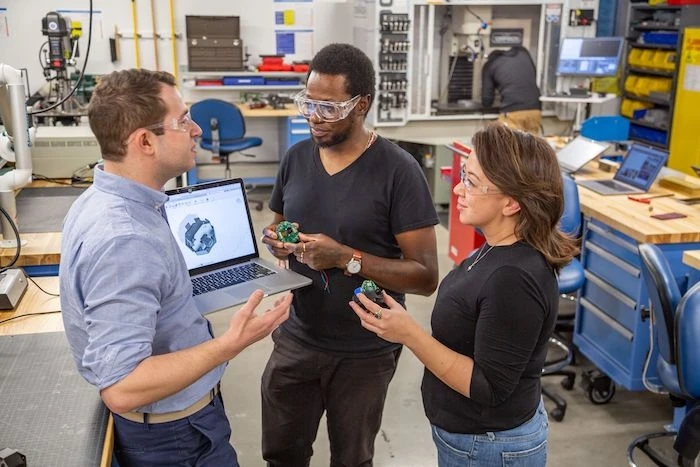 製造用のプロトタイプや3Dモデルの議論を行う同僚たち