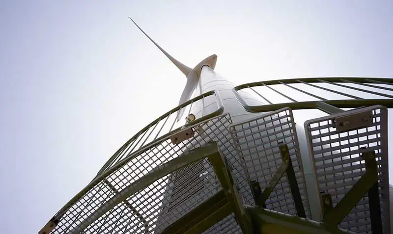 Looking up at a wind turbine