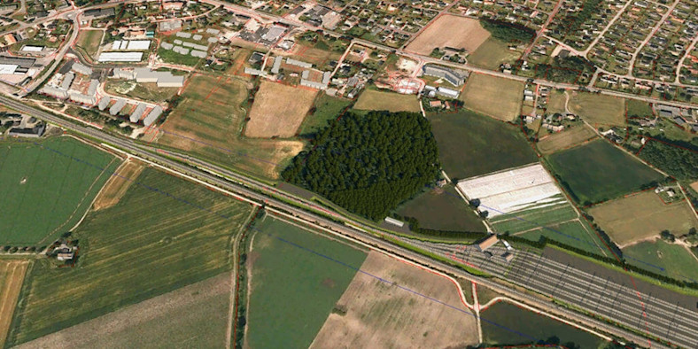 An image of railroad tracks, grassland, and homes.