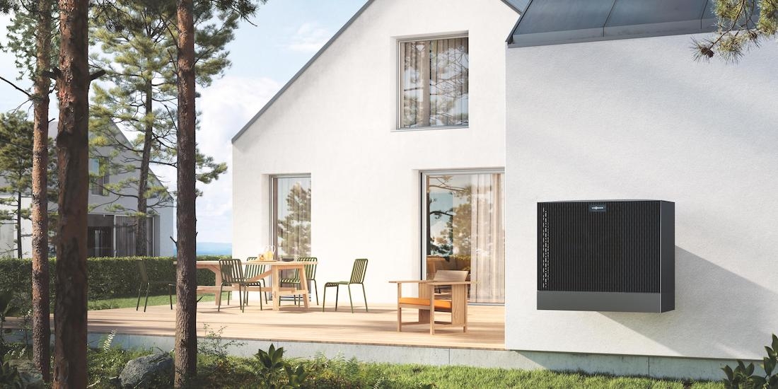 Picture of exterior side of a house with a heat pump unit in the wall