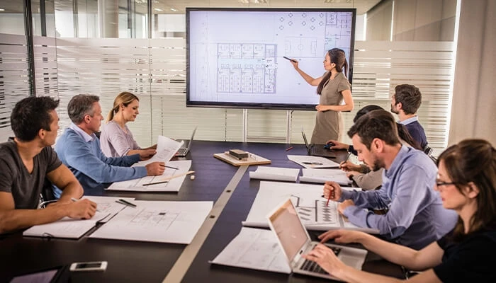 Architects sitting at a table viewing a digital project model during the preconstruction phase