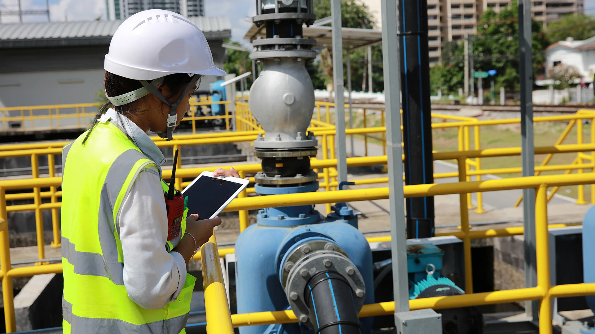 An engineer with a digital tablet inspects a wastewater system.