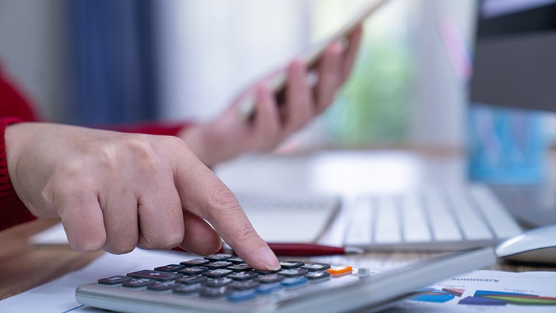 An office worker uses a handheld calculator.