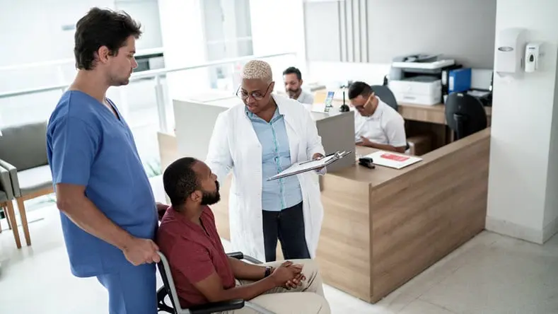 Doctor examining wheelchair patient after surgery 