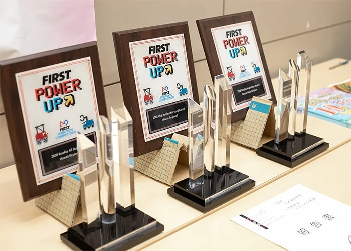 Three FIRST Power Up awards sit on a table.