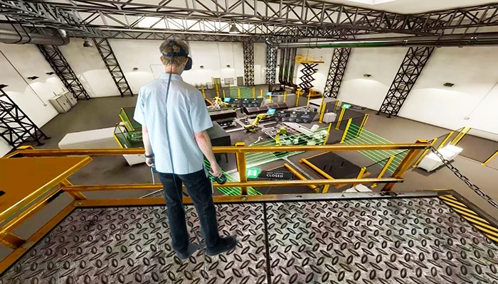 A person wearing VR goggles and experiencing an AR simulation in a factory