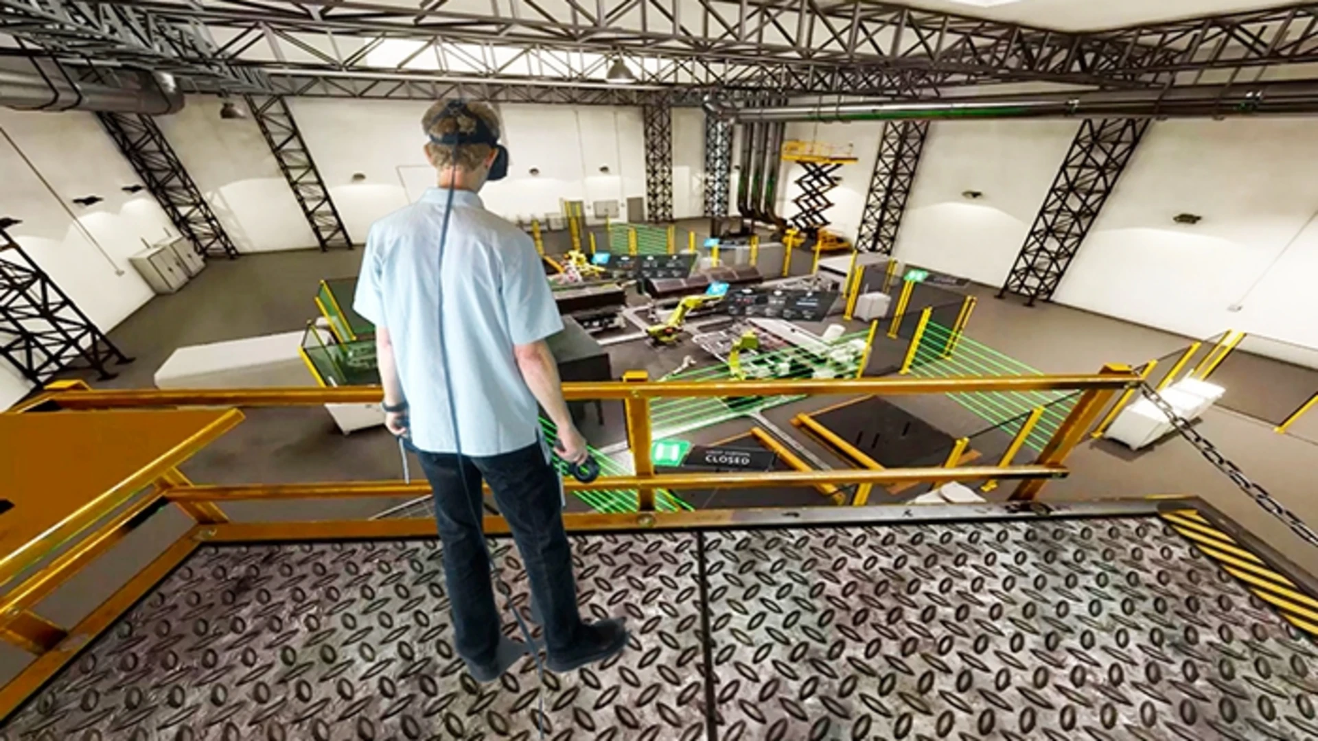 A person wearing VR goggles and experiencing an AR simulation of a factory floor