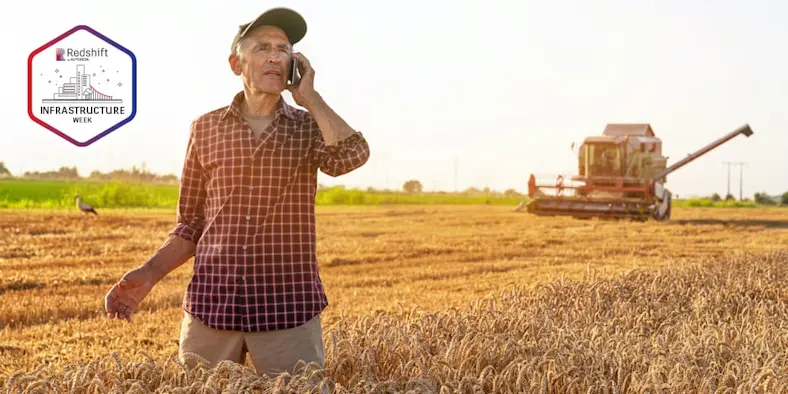 Farmer standing in field talking on cellphone