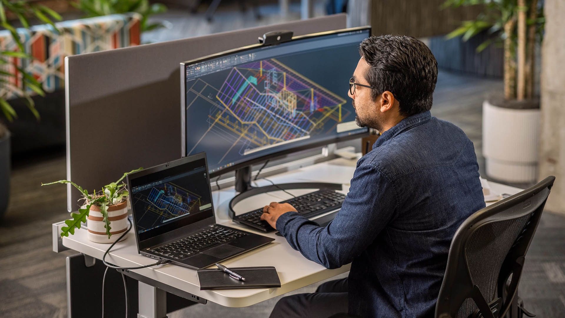 An architect sits at a computer workstation.