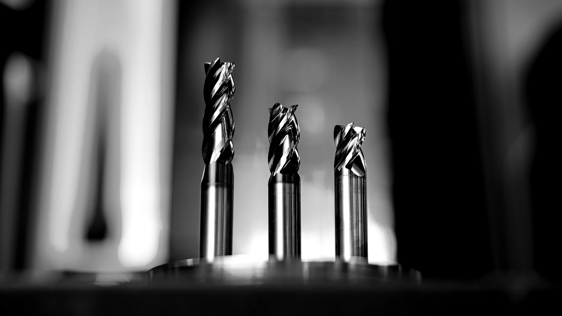 Eine dramatische Nahaufnahme von 3 Vollhartmetall-Schaftfräsern HARVI 1 TE von Kennametal aus der Froschperspektive.