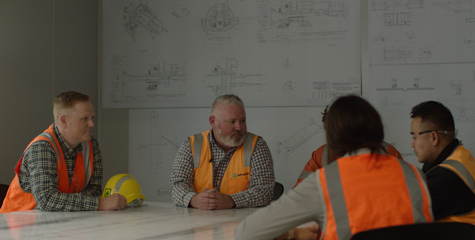 InfraBuild and Sydney Metro project team sat at table having a discussion.