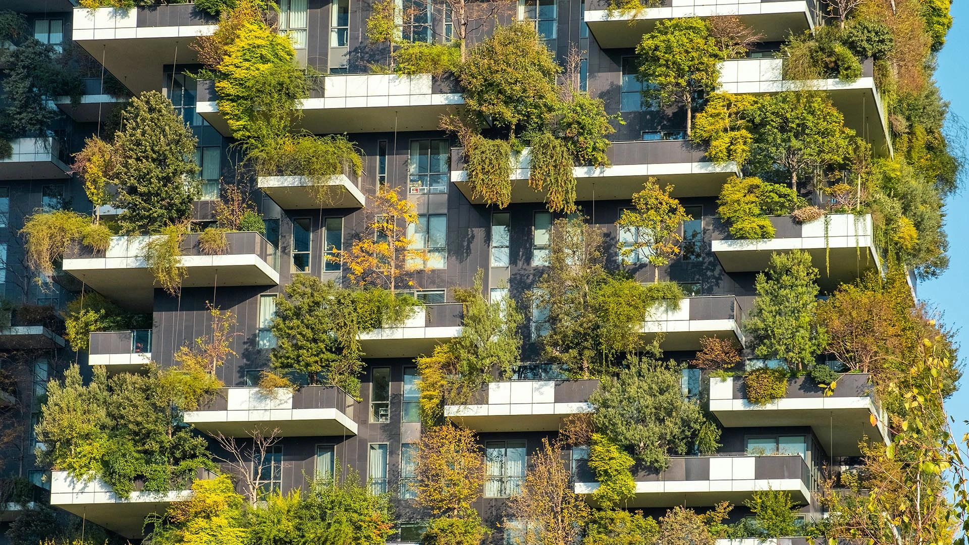 Un edificio residencial de gran altura muestra un bosque vertical, donde la vegetación cubre sus balcones.