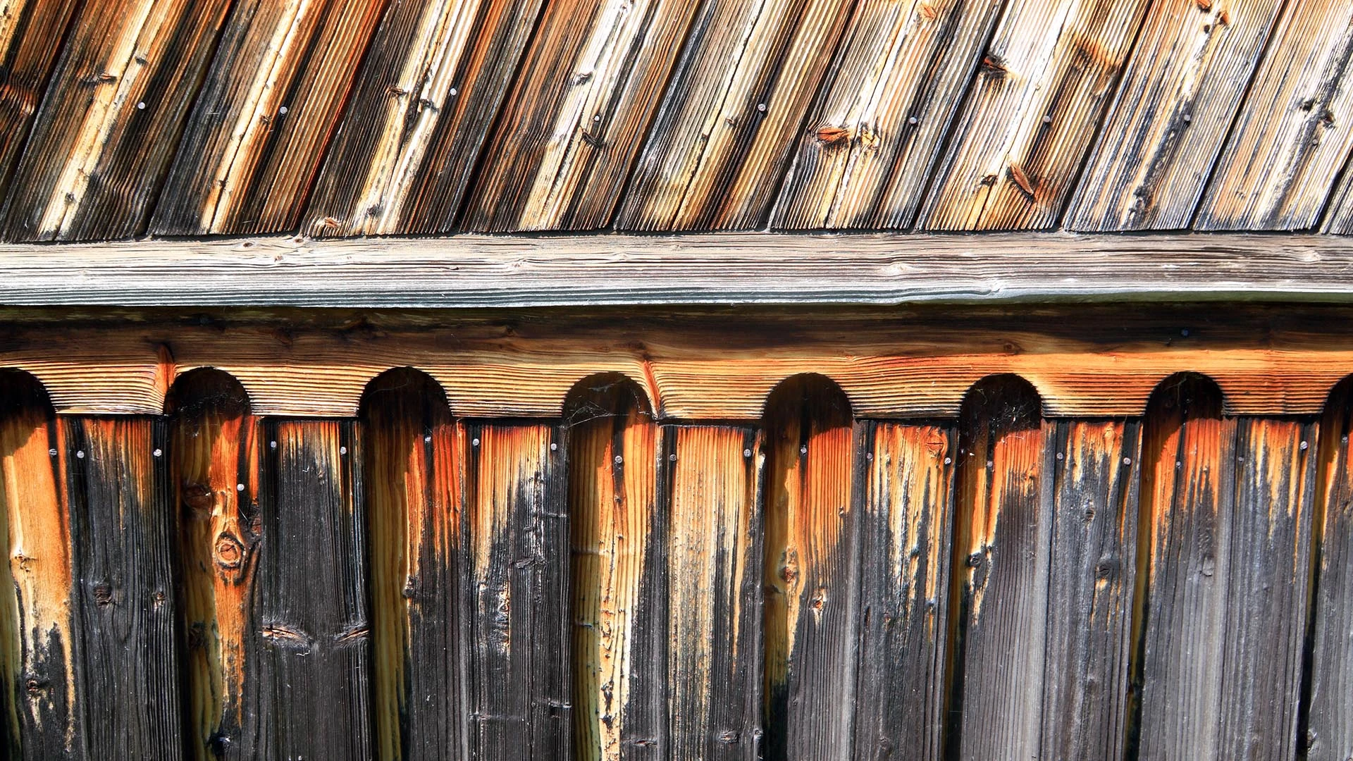 A wooden wall shows signs of extreme weathering.