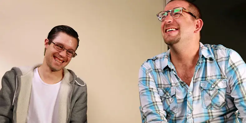 Two people from the Inclyueme program sitting and laughing