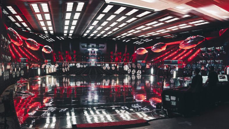 A sound stage with wraparound LED screens displaying the red, futuristic virtual environment of the shuttle bay from season 4 of Star Trek: Discovery.