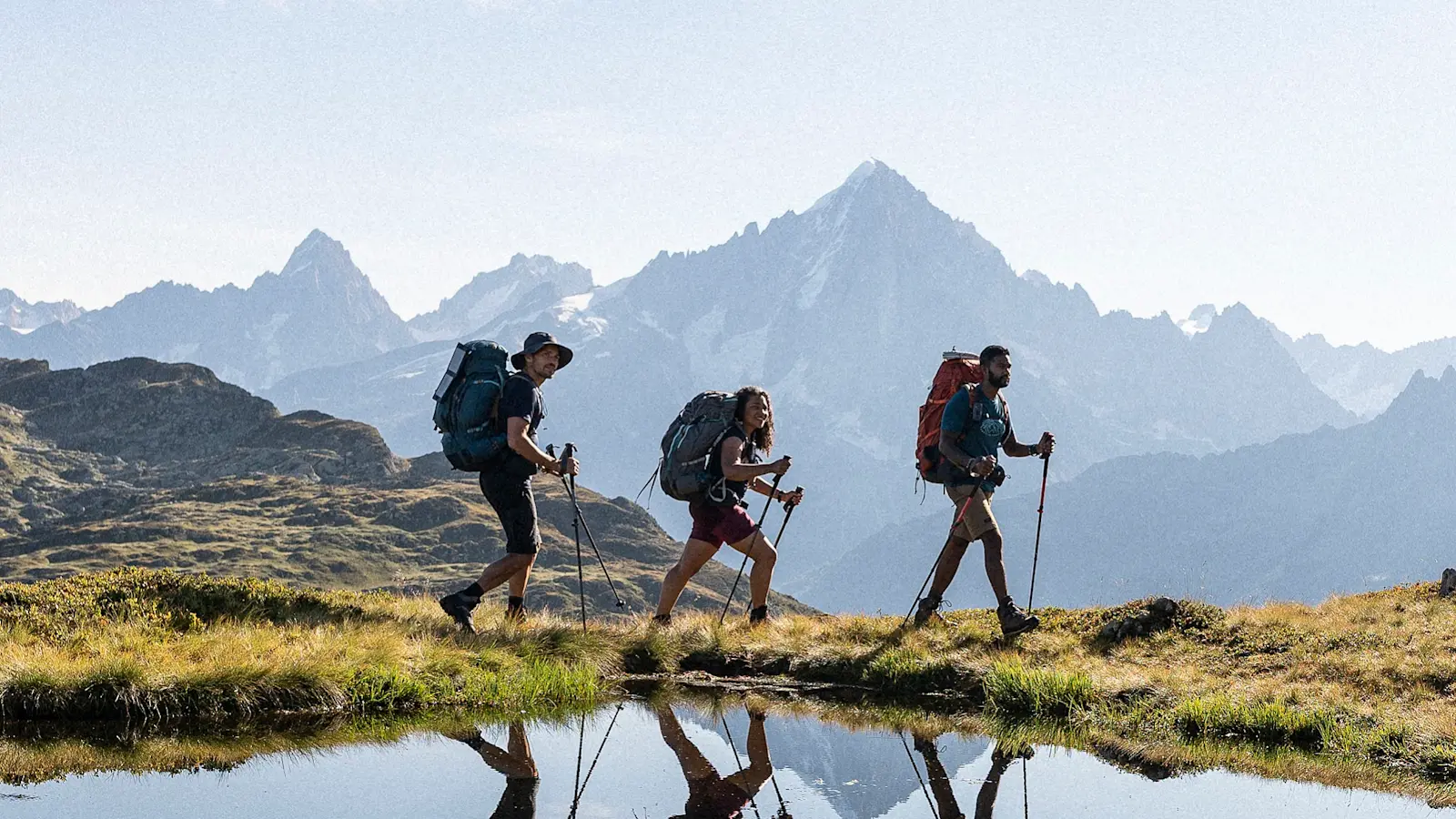 三名徒步旅行者徒步穿越山地景观。