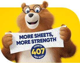 Charmin bear is stretching two sheets of Charmin Essentials to demonstrate product strength. The text on the stretched sheets reads 'more sheets, more strength'.