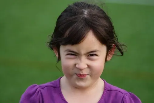 Close up of girl scrunching her face tightly