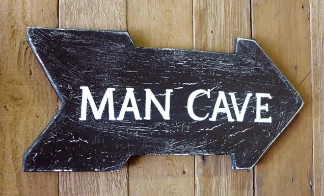 Close-up of right arrow sign with words "Man Cave" written on it
