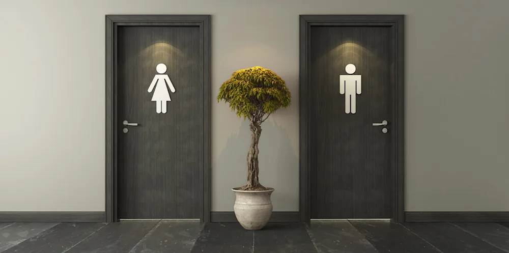 Baño de mujeres y baño de hombres lado a lado en un edificio de oficinas