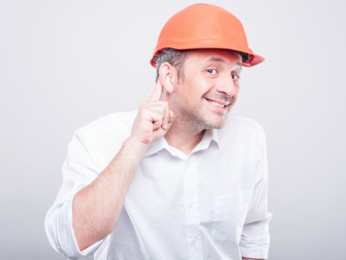 Man in hard hat trying to listen