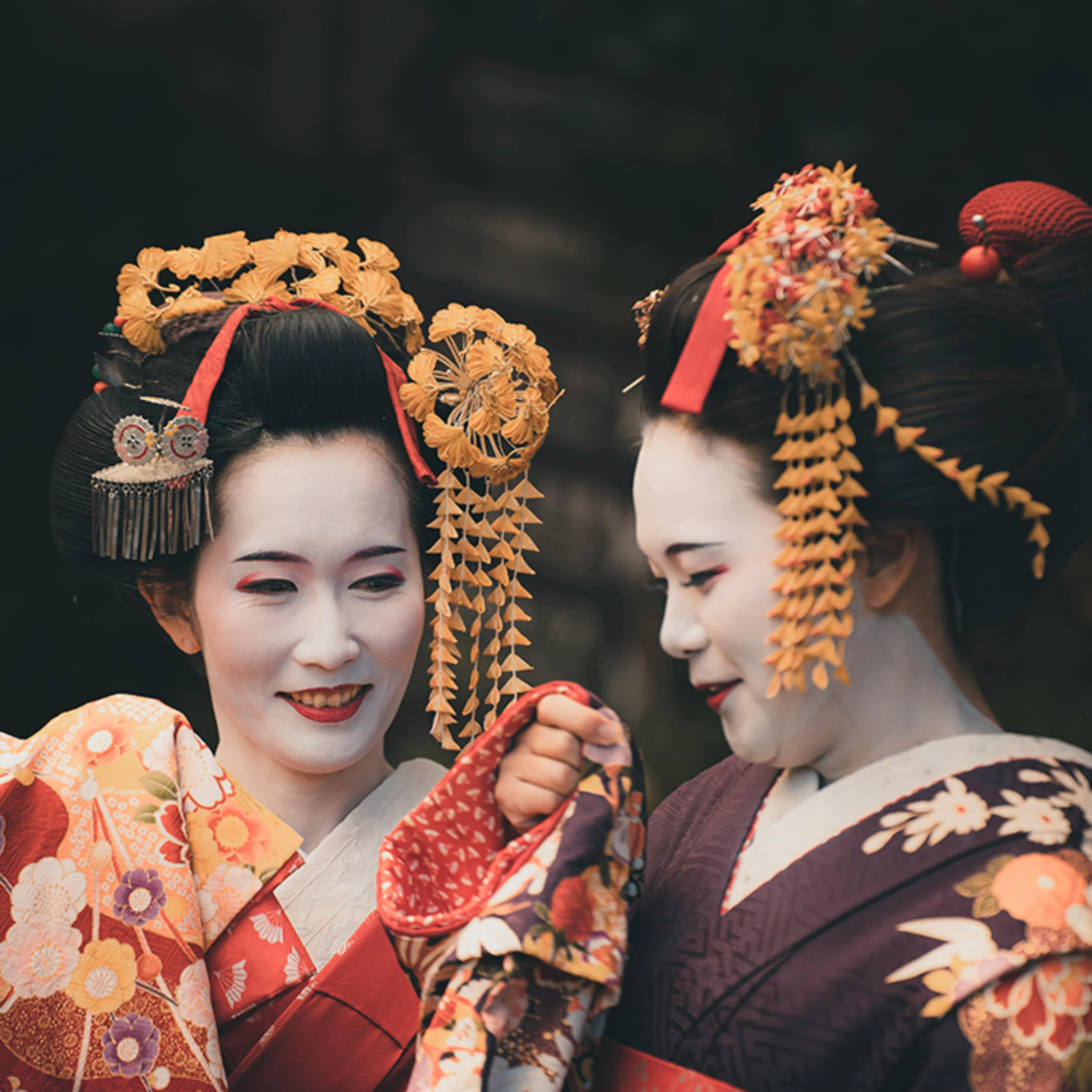two geishas dressed in orange In Japan orange symbolizes love and happiness