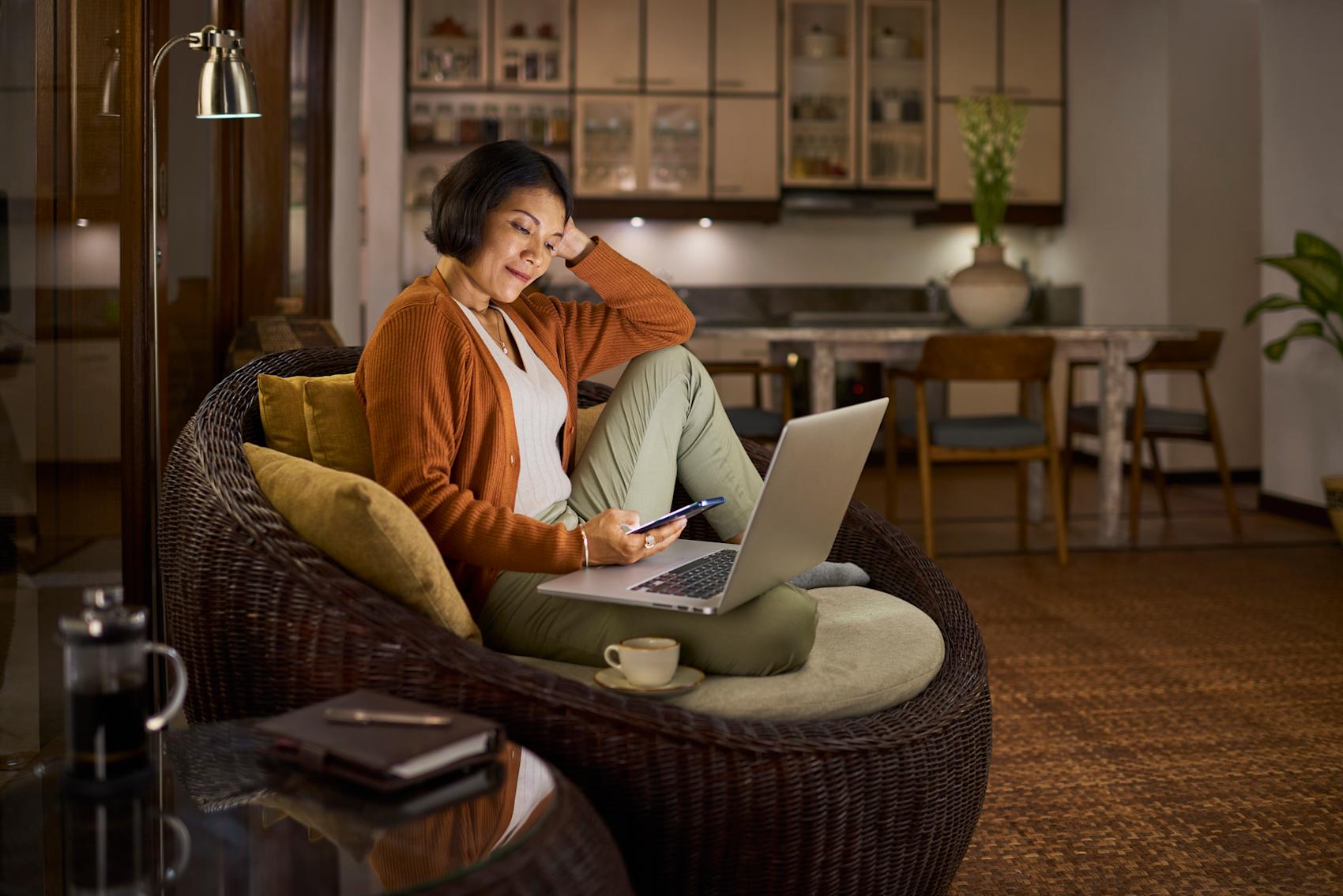 Kvinna i fåtölj med laptop