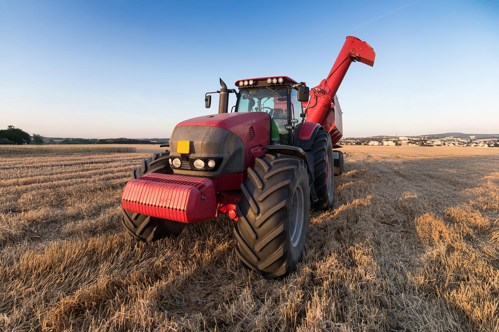Röd traktor på fält