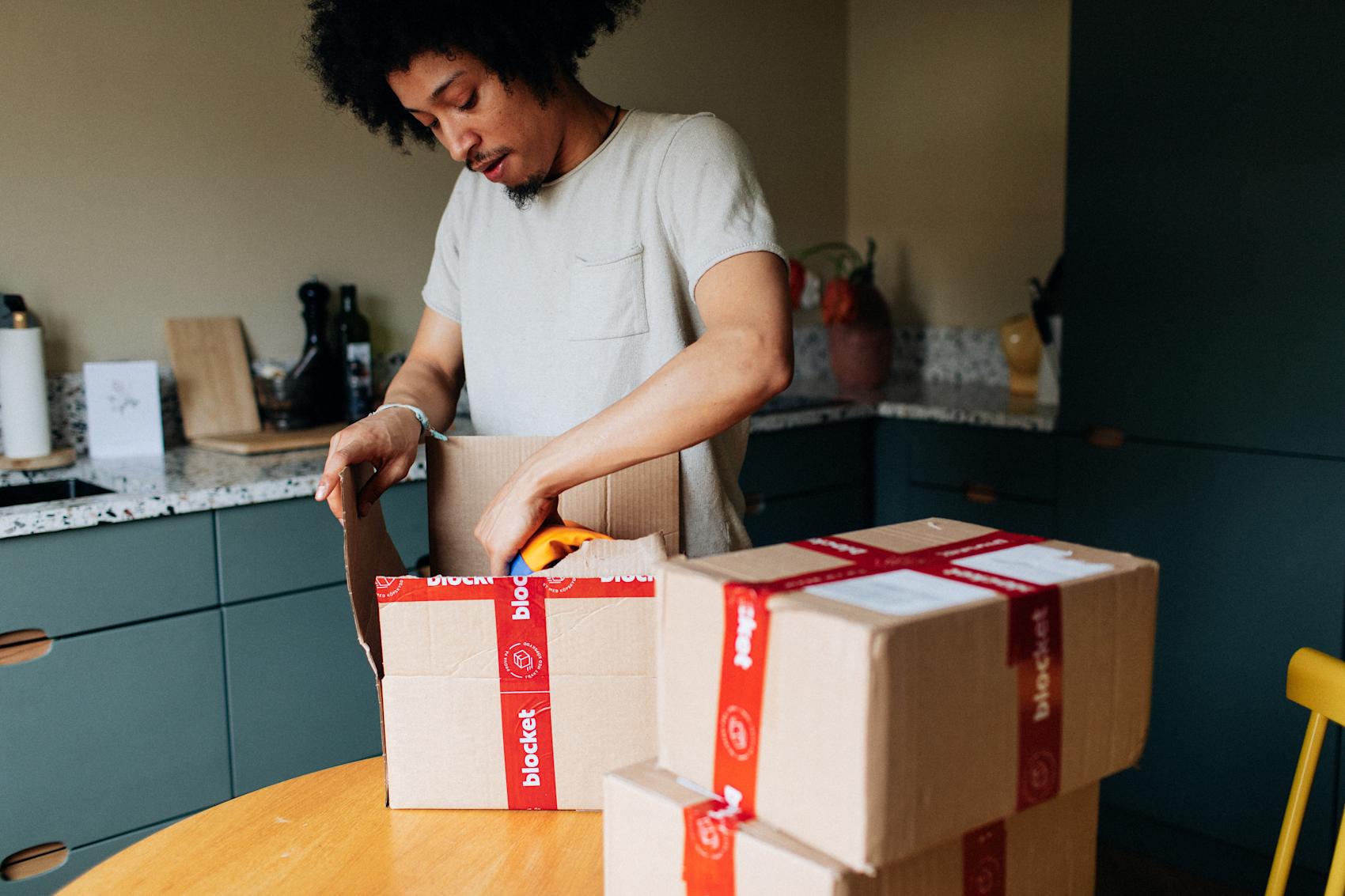 Man slår in paket med röd tejp