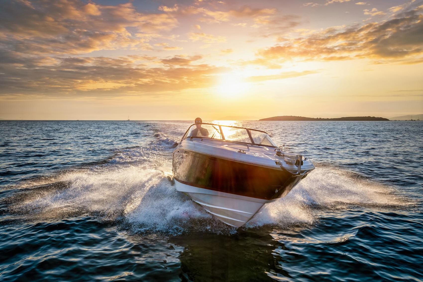 Motorbåt på öppet hav i solnedgång
